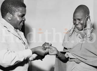 A smiling Masai girl allows a dresser at the Native Hospital at Kajiado to blood slide
